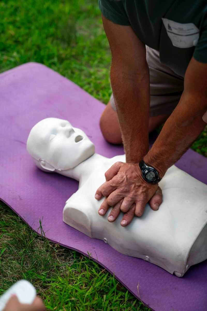 A student practising chest compressions on a CPR manikin during a training session.