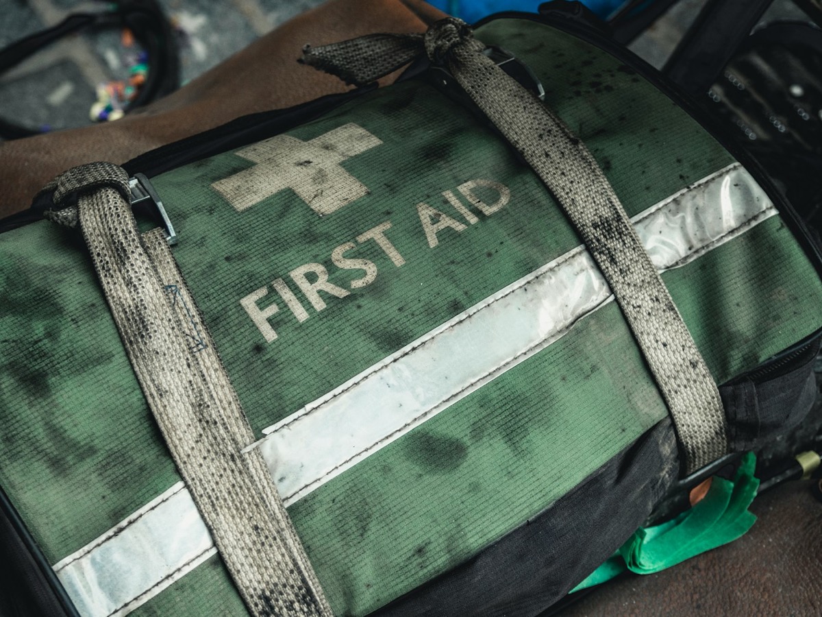 A well-used first aid kit bag on a worksite.